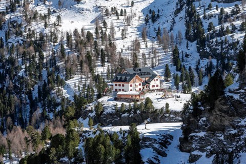 Zufallhütte mountain hut, view of the Martell Valley, snow-covered mountain landscape in winter,