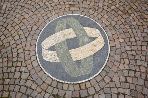 Two round rings with floor mosaic as a symbol of connectedness, paving stones, tyres, circles, into