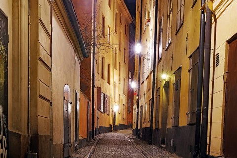 Night shot of a cosy street with old buildings and warm lantern light in a city, winter, Gamla