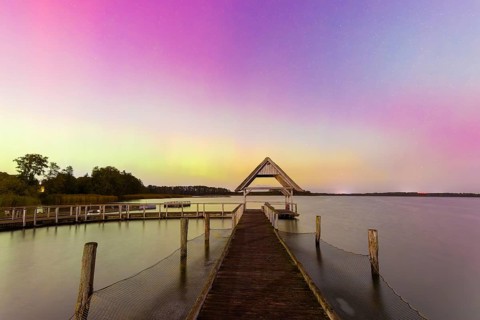 Wooden jetty and Northern Lights, Aurora borealis, polar lights over Lake Hemmelsdorf,