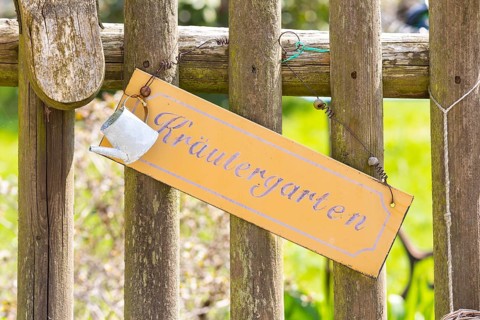 Sign herb garden on a picket fence decorated with a small watering can, Altendorf, Sebnitz, Saxony,