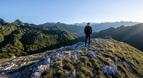 Mountaineer in front of mountain landscape at sunrise, view of mountain peaks of the Venediger