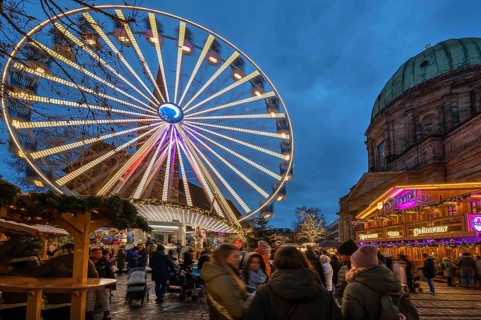 Ferris wheel at the winter village, Christmas market at dusk, St Elisabeth's Church on the right,