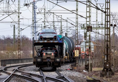 Goods train travelling on the winding Schuster Railway, overhead lines and infrastructure. Car