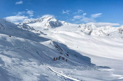 Ski tourers, behind the summit of Monte Cevedale, snow-covered mountain landscape, Ortler Alps,