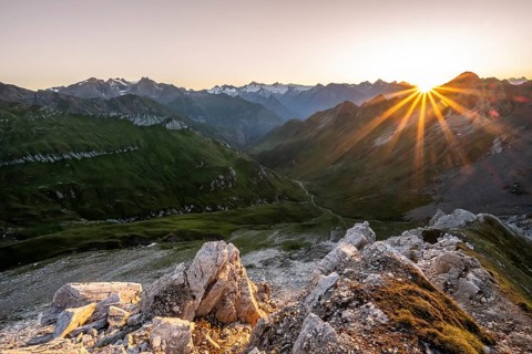 Mountain landscape at sunrise with sun star, view of mountain peaks of the Venediger group and into