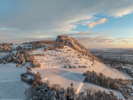 Aerial view of the snow-covered Hegau volcano Hohentwiel with Germany's largest castle ruins on a