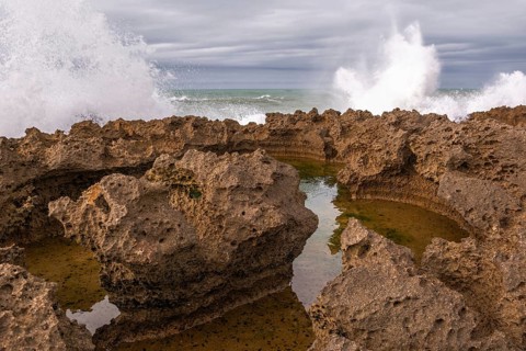 The rocks are scattered throughout the area, with some of them being large and jagged. The water