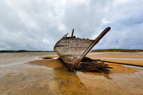 Wooden shipwreck Eddie's Boat on sandy beach, low tide, sandbank, Bunbeg, Magheraclogher beach,