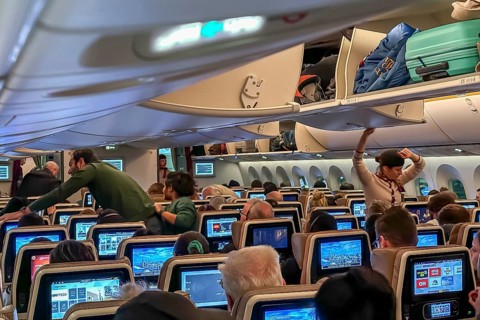 Etihad airline aircraft, interior, rows of seats with passengers. Boeing 787 aircraft on a flight