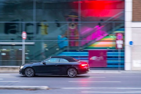 Mercedes at night in front of urban surroundings with modern architecture, pull-along. Stuttgart,