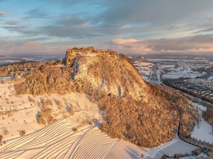 Aerial view of the snow-covered Hegau volcano Hohentwiel with Germany's largest castle ruins on a