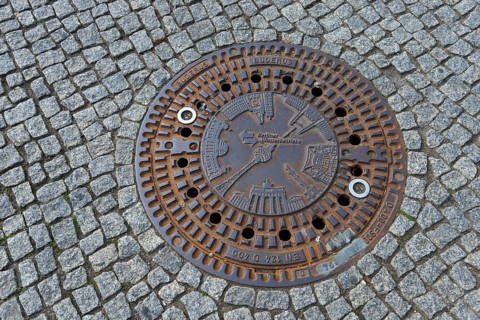 Artfully designed manhole cover on paved street in Berlin, gully cover, manhole cover, Berlin,