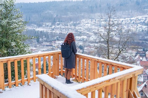 View of a snowy winter landscape from a vantage point with wooden fence, New wooden walkway in Calw
