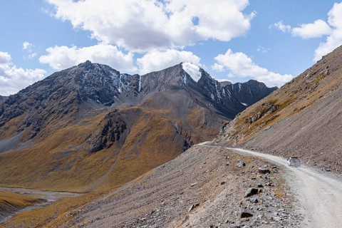 Narrow gravel track in mountain landscape at Chong Ashuu Pass, Tian Shan Mountains, Issyk-Kul,