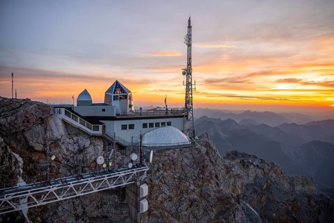 Mountain station of the Tyrolean Zugspitze railway at the summit of the Zugspitze, at sunset,