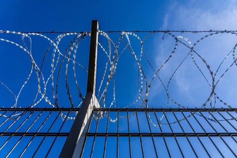 Symbolic image security, S-wire rolls, NATO wire, on a fence top, demarcation of a property,