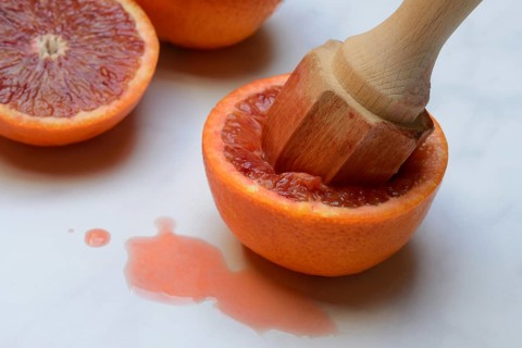 Halved blood orange with citrus squeezer, orange