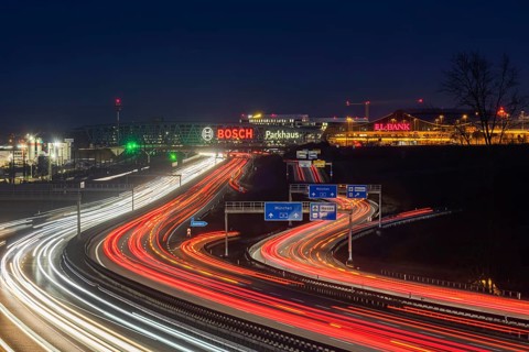 A8 motorway at Stuttgart Airport in the evening. Heavy traffic, lanes of light. Modern architecture
