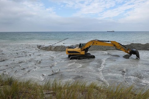 Excavators working to reclaim land on the beach of the Darß peninsula, Mecklenburg-Western