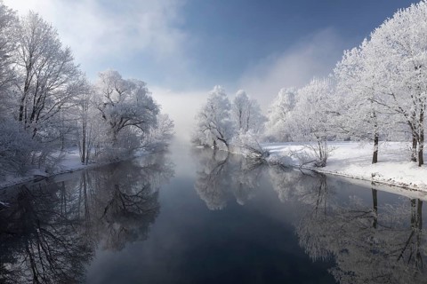 Lake Kochelsee in Bavaria, Germany. River Loisach leaving the lake. Winter, hoar frosted trees