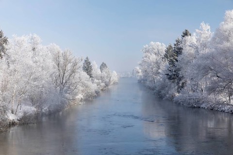 Lake Kochelsee in Bavaria, Germany. River Loisach leaving the lake. Winter, hoar frosted trees