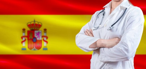Doctor with crossed arms on Spain flag. Spain Health and Care concept. Female doctor on Spain flag