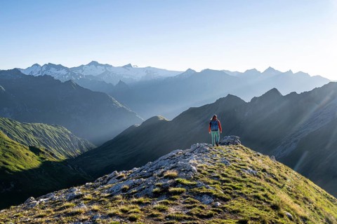 Hiker enjoying the mountain panorama in the morning, Venediger group, behind Dreiherrenkopf,