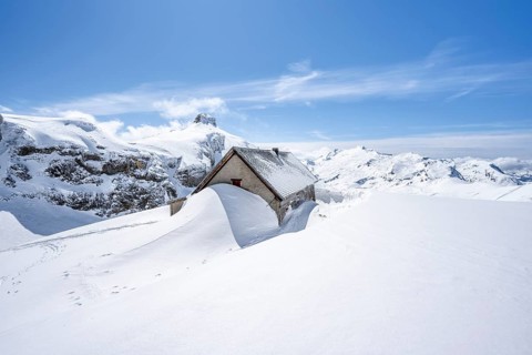 Snow-covered hut in winter, mountain landscape with snow, behind summit Rohrbachstein and Wildhorn,