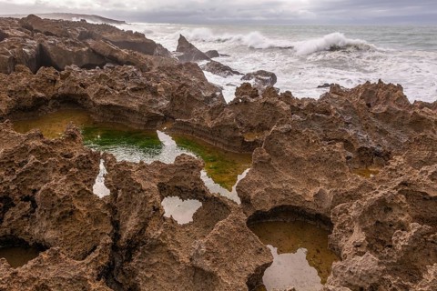 The rocks are scattered throughout the area, with some of them being large and jagged. The water