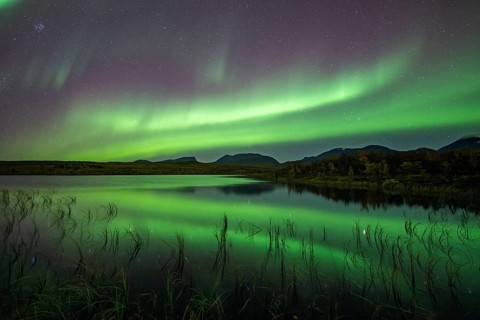 Northern lights reflected in lake, Lapporten, Abisko National Park, Lapland, Sweden, Europe