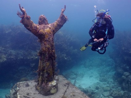 Diver looking at the statue of Jesus Christ underwater (Christ of the Abyss), dive site John