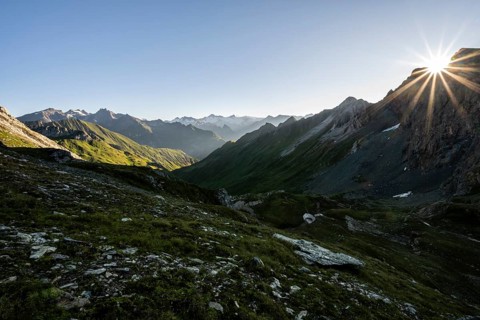 Mountain landscape at sunrise with sun star, view of mountain peaks of the Venediger group and into