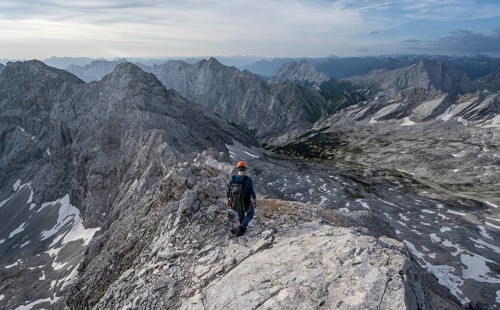 Mountaineer with helmet on a narrow rocky ridge, crossing the Jubiläumsgrat, Wetterstein range,