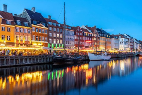 Colourful houses, restaurants and historic ships on the Nyhavn canal and harbour at dusk,