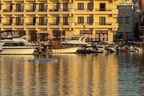 Stand-up paddlers in the harbour of Chania, Crete, Greece, Europe