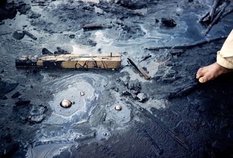 Moving stream of tar carrying pieces of wood, La Brea Pitch Lake, Trinidad, early 1960s