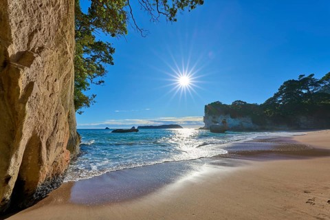 Sun shining on a picturesque beach with rocks, Cathedral Cove, Coromandel, Canterbury, North