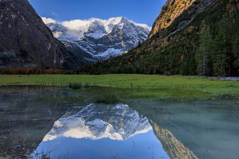 Snow-covered mountains reflected in lake, pond, autumn, Großer Ahornboden, Karwendel Mountains,