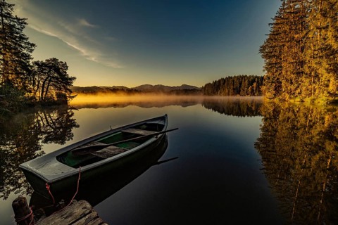 Boats in the autumnal Schmutter Weiher in the Allgäu near the municipalities of Halblech,