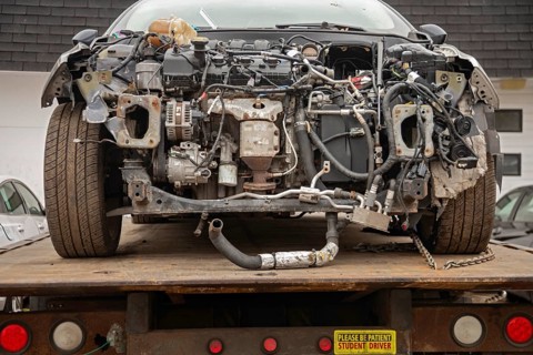 Detroit, Michigan - A wrecked car on a flatbed truck with a sticker that says: Student Driver.
