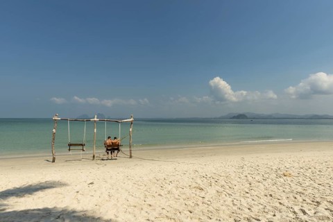 Gay couple in a swing on the beach of Koh Mook Island, Andaman Sea, Satun Province, Southern