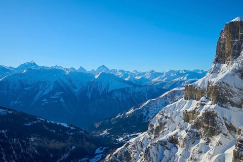Snowy mountain landscape with clear blue sky and rocky peaks in alpine surroundings, Gemmi Pass,