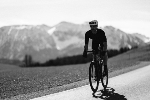 Road bike rider in spring near Halblech in the Allgäu in front of a picturesque backdrop of the