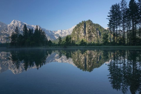 Lake Almsee in summer with totally smooth surface showing reflexion of the mountain Ameisstein