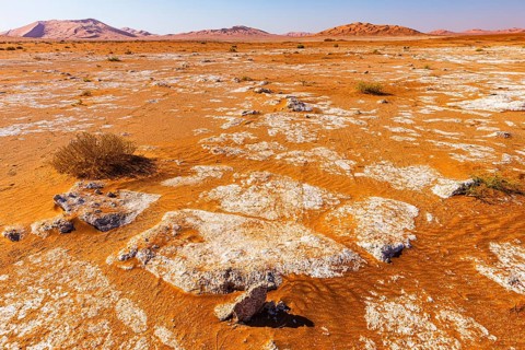 Flat plain interspersed with rocks, between sand dunes, in Rub al Khali desert, Dhofar province,