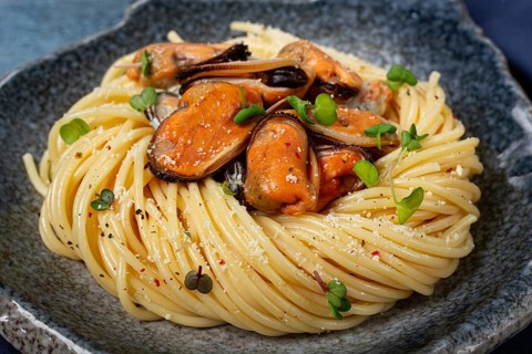 Spaghetti with mussels, without shell, pasta with peeled mussels, in carbonara sauce, micro-greens,