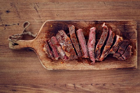 Medium rare, sliced rib eye steak, grilled cowboy steak, on a chopping board, close-up, homemade,