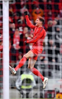 Goal celebration jump Leon Goretzka FC Bayern Munich FCB (08) behind goal net, Allianz Arena,