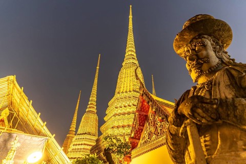 Giant Farang Guard and Chedi of the Buddhist temple Wat Pho at dusk, Bangkok, Thailand, Asia